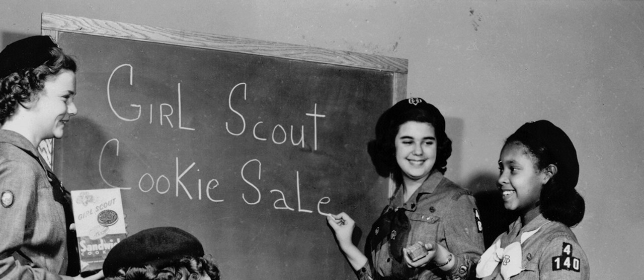 Girl Scouts at blackboard planning a Girl Scout Cookie Sale Girl Scouts at blackboard planning a Girl Scout Cookie Sale